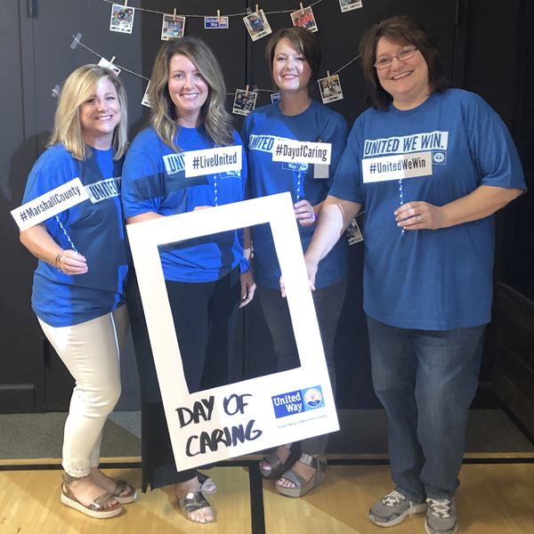 Four Kappler employees in blue United Way shirts holding a Day of Caring photo frame