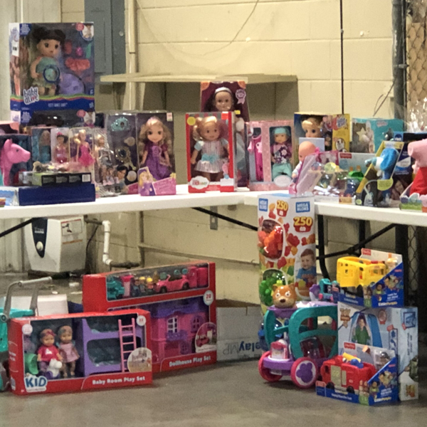 Tables of donated toys, dolls, and play sets collected for a Kappler community giving drive