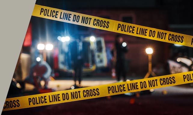 Yellow Police Line Do Not Cross tape at a nighttime emergency response scene