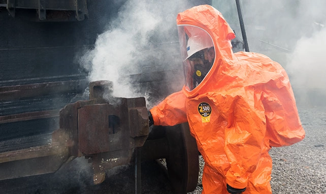 Responder in an orange Kappler encapsulating suit handling a leaking railcar valve