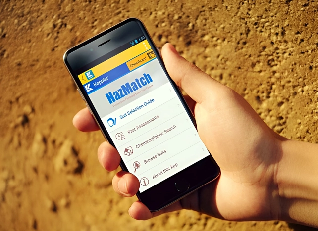 Hand holding a phone showing the HazMatch protective clothing selection app outdoors